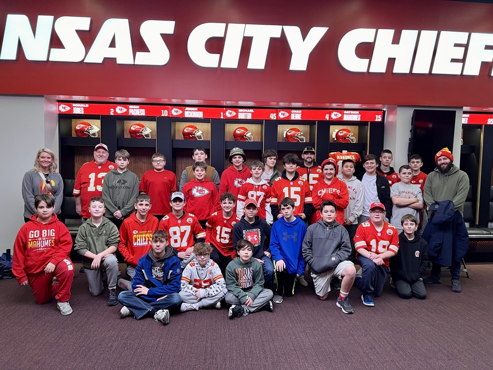 Students stand in front of locker cubbies in the locker room at Arrowhead Stadium