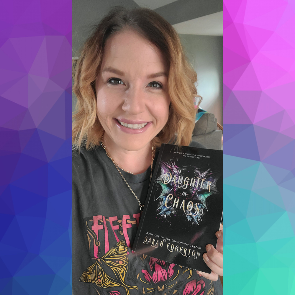 Sarah Moore wearing a gray t shirt holding a black paperback book
