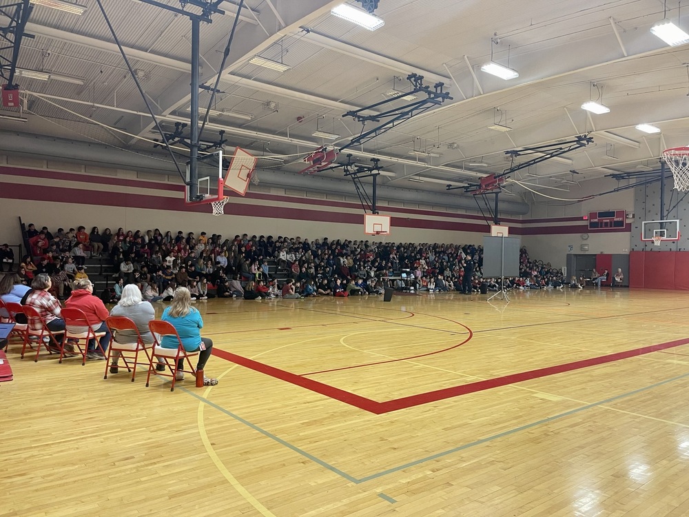 Middle school students sit in bleachers in the TMS gym