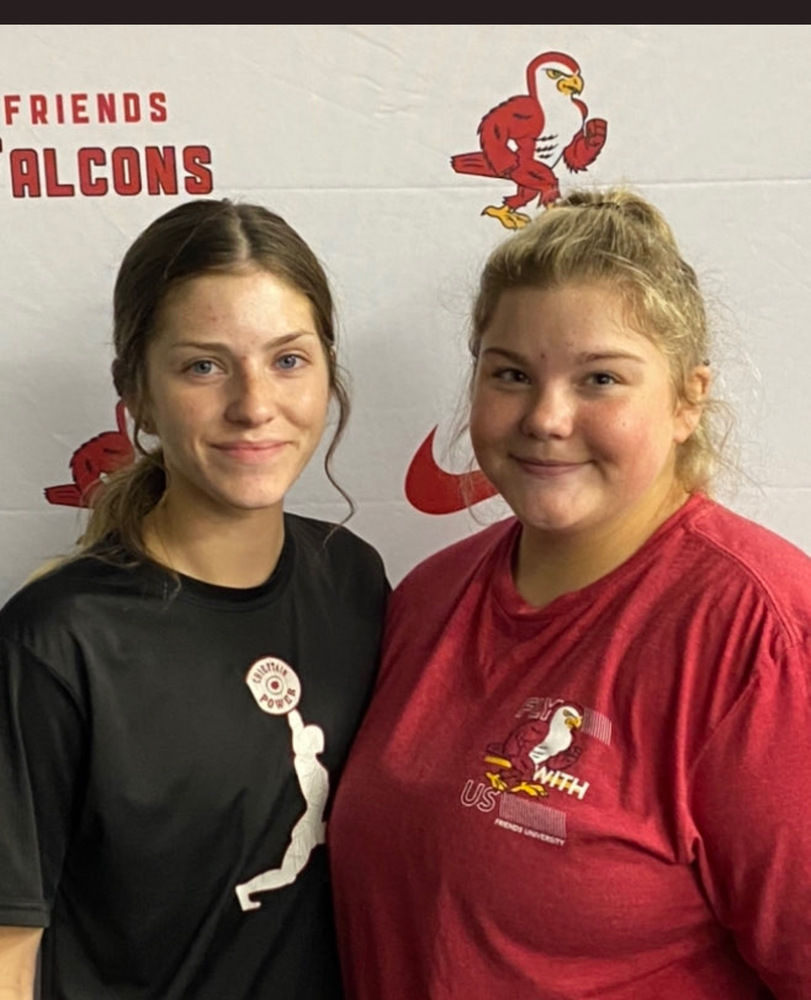 Haley Robinette (L, wearing black shirt) and Ally Sparks (R, wearing red shirt) stand together in front of a Friends Falcon branded screen