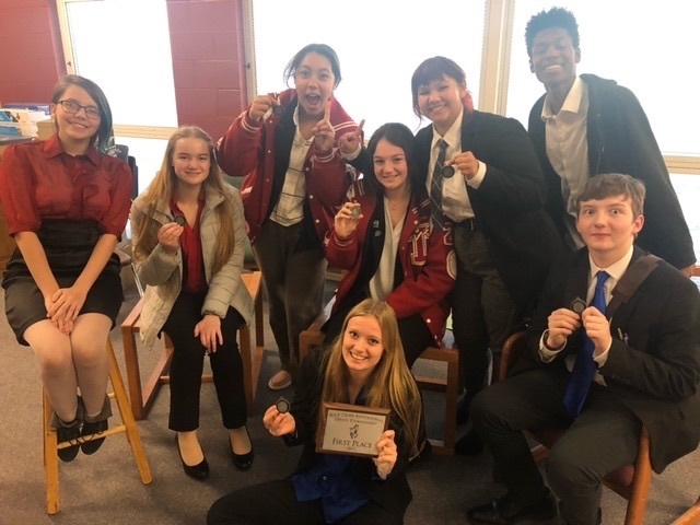 debate team members pose with medals