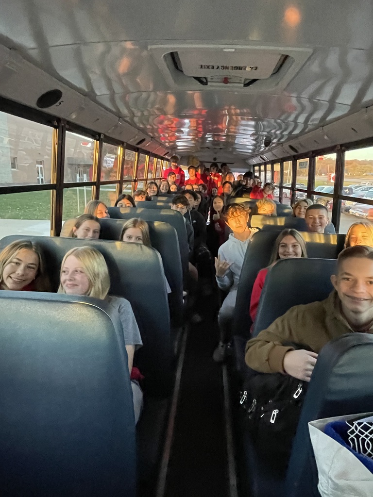 View from front of a school bus of high school students sitting in seats