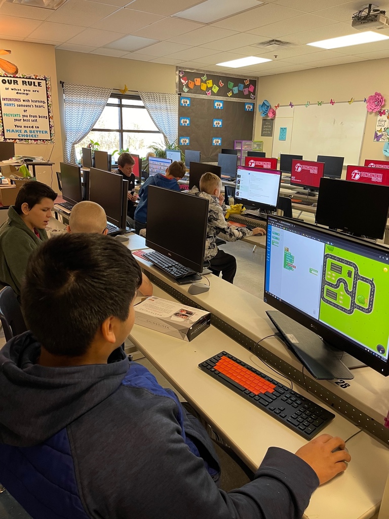 Students play code-breaking games on computers in a classroom.