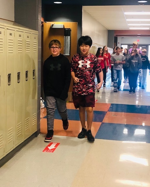 Middle school students walk down a hallway