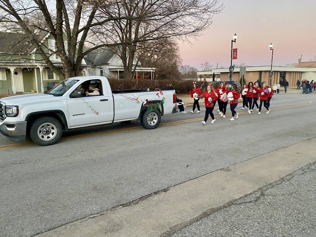 White truck drives in front of group of cheerleaders