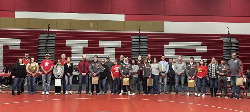 senior wrestlers stand in a line with their families
