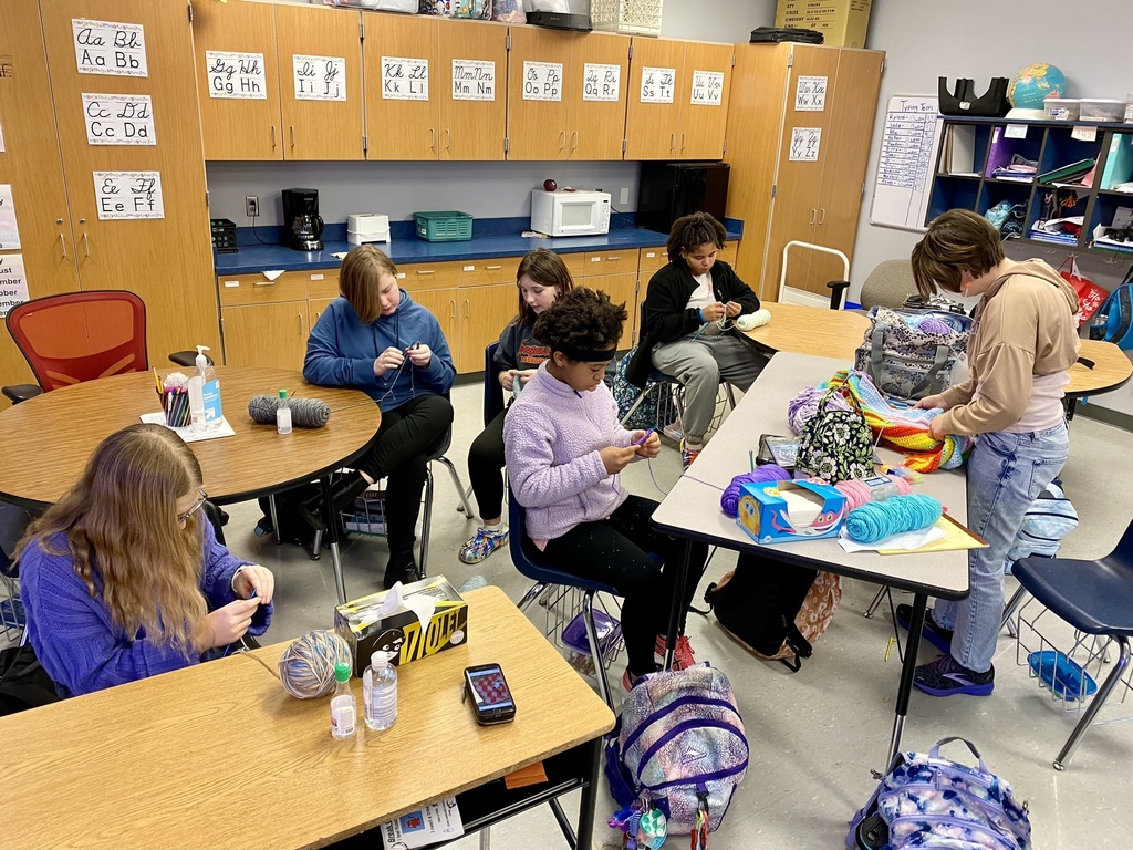 classroom of students use knitting needles 