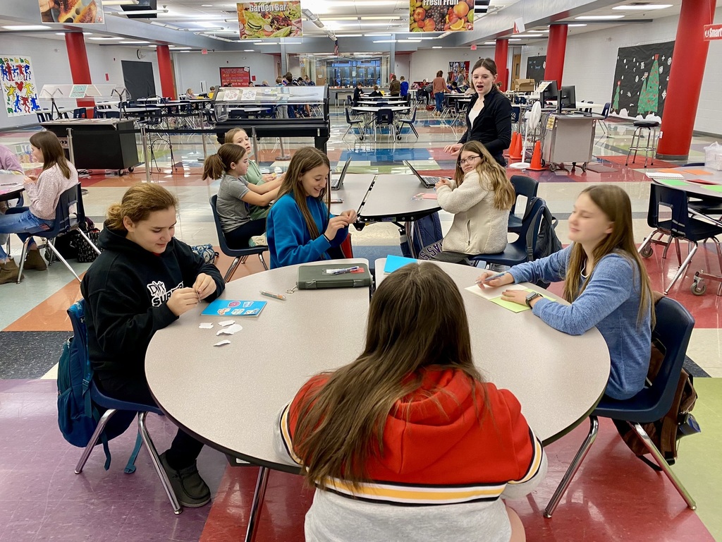 fccla members sit at round tables in the cafeteria while they work on journaling