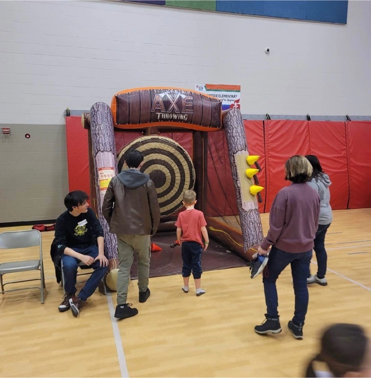 children throw foam axes at an inflatable ax throwing stand
