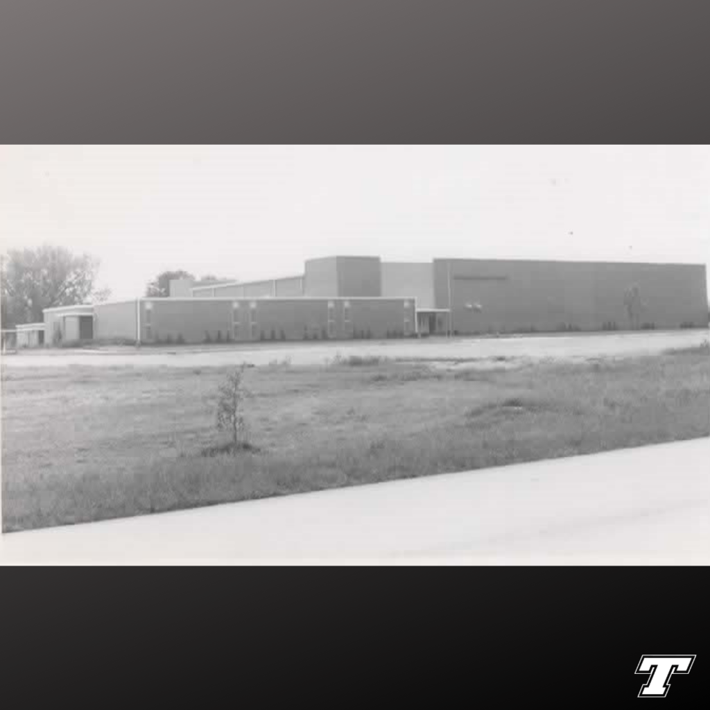 black background with black and white image of Tonganoxie High School in foreground