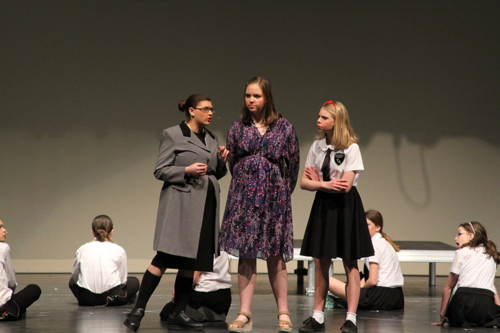 Three students stand together on stage as they say their lines for Matilda Jr.