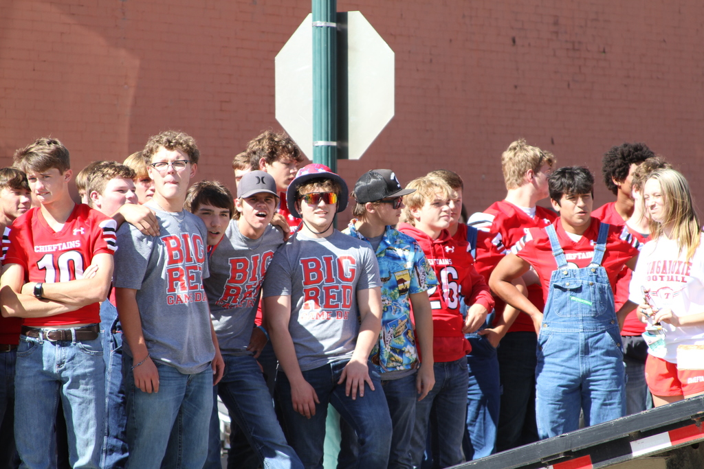 teenagers wearing gray t shirts and red football jerseys