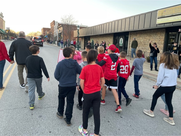 fifth graders walk down the street during the Christmas parade